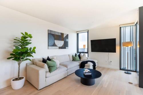 a white living room with a couch and a table at The Pearl Coast - Rooftop Pool, Gym Luxurious 2BR Santa Monica in Los Angeles