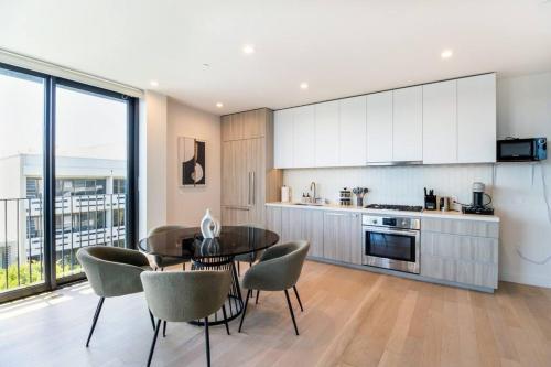 a kitchen with a table and chairs in a room at The Pearl Coast - Rooftop Pool, Gym Luxurious 2BR Santa Monica in Los Angeles