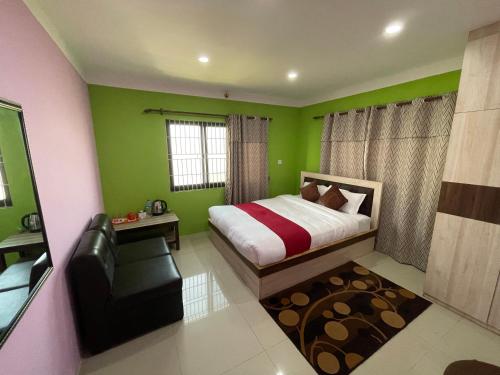 1 dormitorio con paredes verdes, 1 cama y 1 silla en Chareli Resort, en Nagarkot