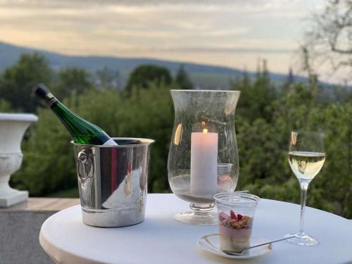 - une table avec une bouteille de vin et une bougie dans l'établissement Villa 1907 Wissembourg, à Wissembourg