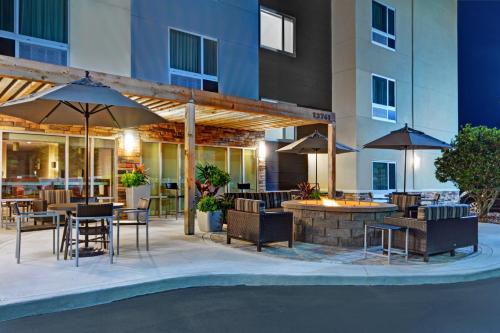 an outdoor patio with tables and chairs and umbrellas at TownePlace Suites by Marriott Jacksonville East in Jacksonville
