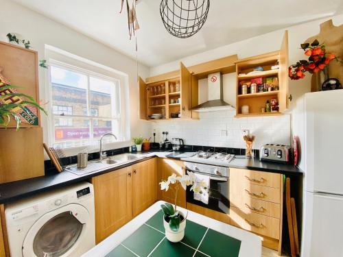a kitchen with a sink and a dishwasher at London's Central East End 2 Bedroom City Apartments in London