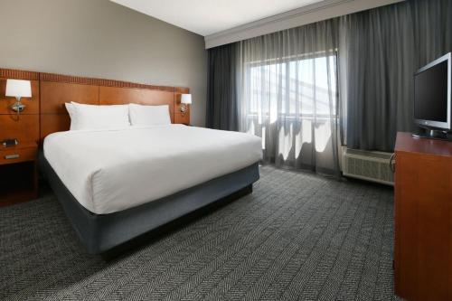 a hotel room with a bed and a television at Courtyard Dallas Las Colinas in Irving