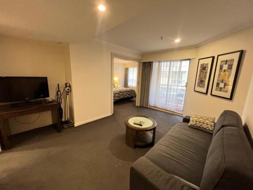 a living room with a couch and a flat screen tv at Excellent location,Darling Harbour in Sydney