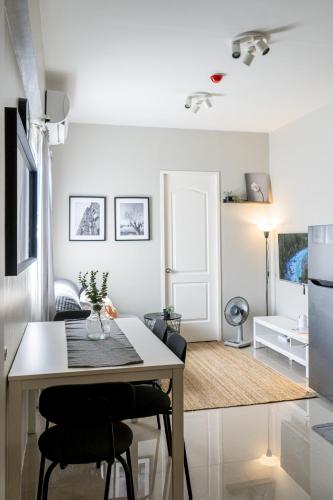 a kitchen and living room with a table and chairs at Cozy 1-bed unit near SRP Talisay Cebu in Talisay