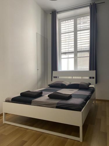 un lit dans une chambre avec une grande fenêtre dans l'établissement Appartement hyper centre, à Lyon