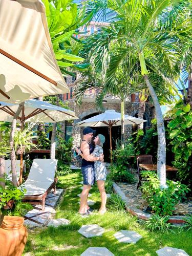 a man and woman kissing under an umbrella at Sầm Sơn Boutique Hotel Phan Thiết in Phan Thiet