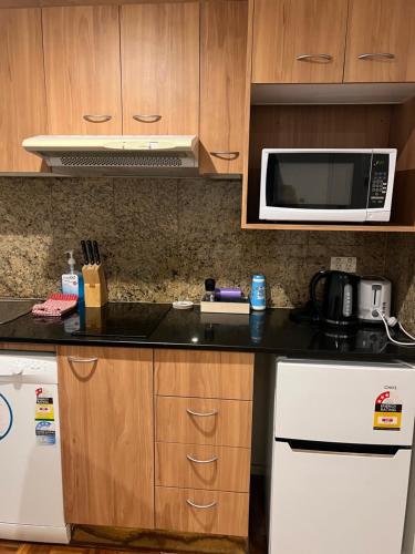 a kitchen with a microwave and a white refrigerator at Excellent location,Darling Harbour in Sydney