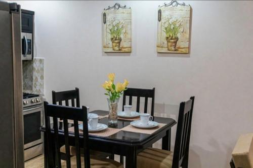 a dining room with a table with chairs and flowers on it at Casa De Llewellyn's Apartments in Kelly Village