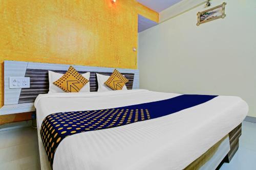 a bedroom with a large bed with yellow walls at SPOT ON Shreekrupa in Mahabaleshwar