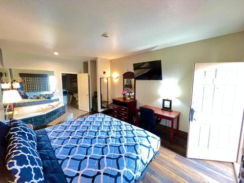a bedroom with a bed and a desk and a room at Magnolia Inn and Suites in Magnolia