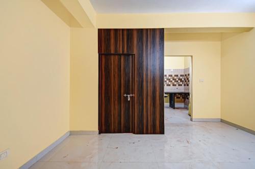 a wooden door in the middle of a room at Super Hotel O Shree Residency in Thākurdwari