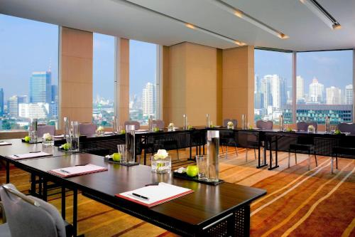 a restaurant with tables and chairs and large windows at Bangkok Marriott Hotel Sukhumvit in Bangkok