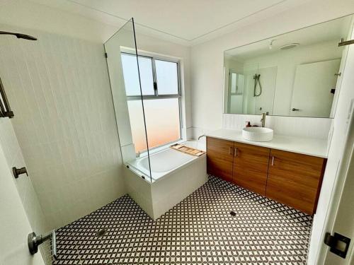 a bathroom with a glass shower and a sink at Abrolhos Beach House in Geraldton