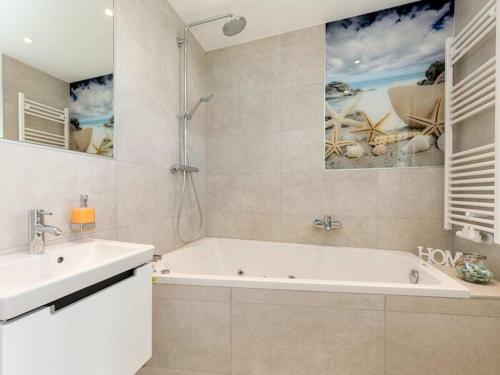 a bathroom with a bath tub and a sink at Holiday Home Traumzeit I in Zingst