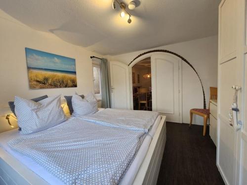 a bedroom with a bed with a white comforter at Raphael - "Elvis Presley" in Timmendorfer Strand