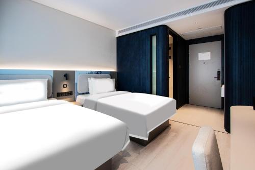 Un ou plusieurs lits dans un hébergement de l'établissement Atour Light Hotel Hangzhou West Lake Lakeside Qinghefang