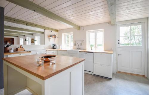 a large kitchen with white cabinets and a wooden ceiling at Lovely Home In Silkeborg in Silkeborg