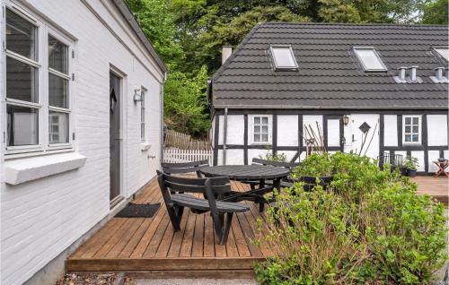 a wooden deck with a table and a house at Four-Bedroom Holiday Home In Juelsminde in Juelsminde