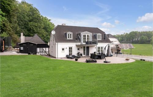 a large white house with a large yard at Four-Bedroom Holiday Home In Juelsminde in Juelsminde