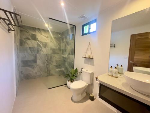 a bathroom with a toilet and a sink and a shower at Gandalupa Villas Elnido in Langi-langiban