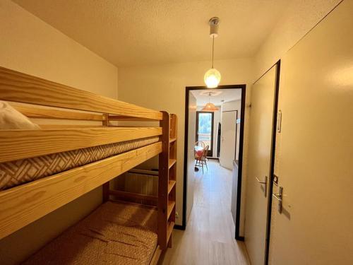 Cette chambre comprend 2 lits superposés et un couloir. dans l'établissement Charmant T2 proche pistes avec parking et balcon - FR-1-787-79, à Laveissière