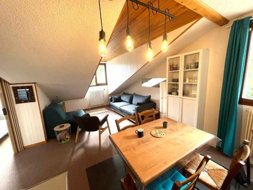 un salon avec une table et un canapé dans l'établissement Studio confort à Méaudre - Ski & parking privé - FR-1-737-88, à Méaudre