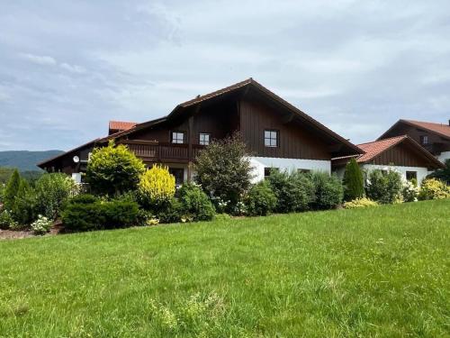 a house with a green lawn in front of it at Sonnenblick Comfortable holiday residence in Grafenwiesen