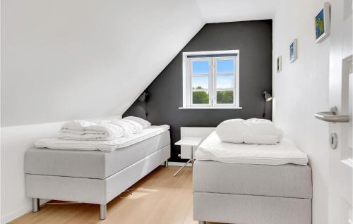 two beds in a room with a attic at Four-Bedroom Holiday Home In Juelsminde in Juelsminde