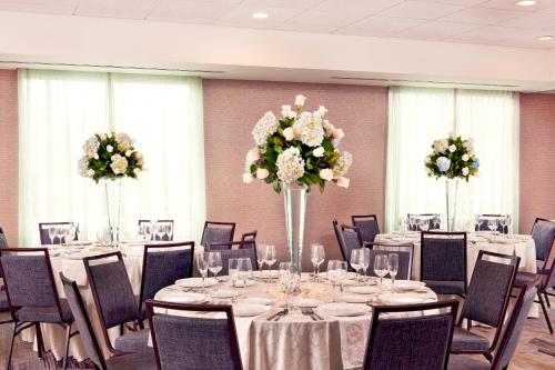 a banquet room with tables and chairs with flowers at Courtyard by Marriott Yonkers Westchester County in Yonkers