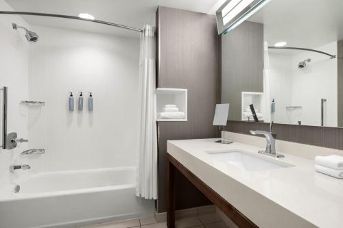 a bathroom with a tub and a sink and a shower at Courtyard by Marriott Omaha East/Council Bluffs, IA in Council Bluffs