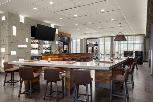 a lobby with a large bar with chairs at Courtyard by Marriott Omaha East/Council Bluffs, IA in Council Bluffs