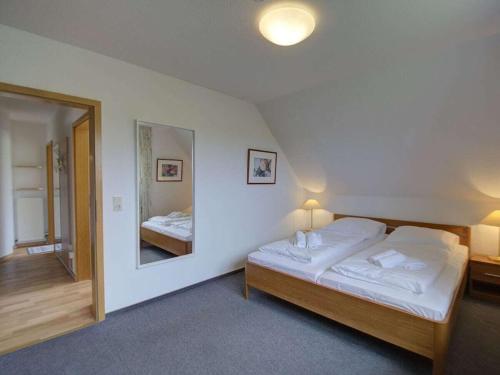 a bedroom with a bed and a large mirror at Holiday Apartment on the Golf Course F 5 O in Fehmarn