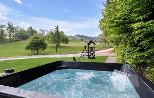 a pool of water with a swing in a yard at Four-Bedroom Holiday Home In Juelsminde in Juelsminde
