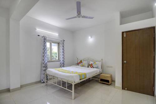 a bedroom with a bed and a window and a door at Hotel O Muktesh Chandra in Goa