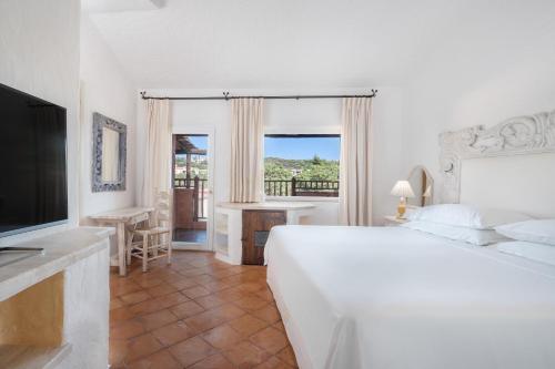 a white bedroom with a bed and a television at Cervo Hotel,Costa Smeralda Resort in Porto Cervo