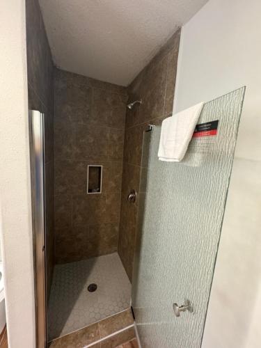 a shower with a glass door in a bathroom at Southwind Inn in Port Isabel