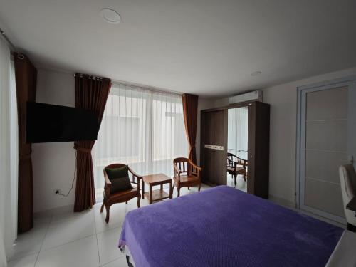 a bedroom with a bed and a table and chairs at Rumah Menik in Uluwatu