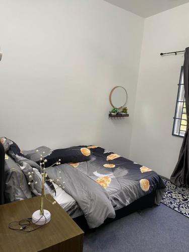 a bedroom with a bed and a table with a table at Kencana L&K Homestay in Air Molek