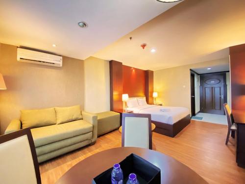 a hotel room with a bed and a couch at Fancy and Nice Studio at El Royale Apartment By Travelio in Bandung
