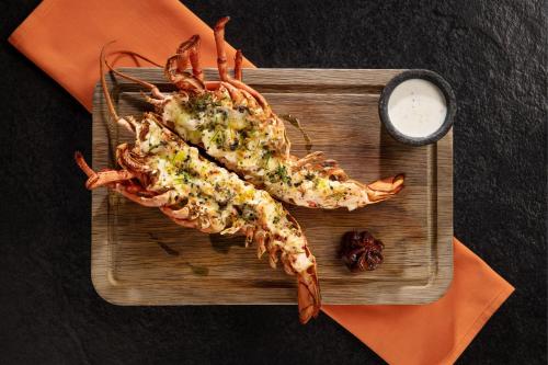 two lobsters on a cutting board with a sauce at JW Marriott Marquis Hotel Dubai in Dubai