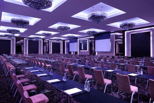 a large room with tables and chairs and chandeliers at JW Marriott Marquis Hotel Dubai in Dubai