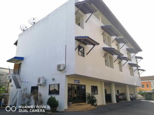 a large white building with windows at Suwanna Hotel krabi town in Krabi