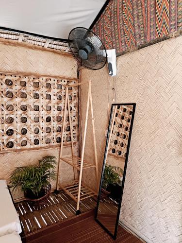 a room with a fan and potted plants on a wall at Bucana Beach House North El Nido in El Nido