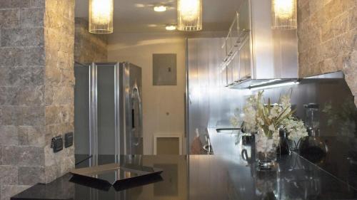 una cucina con frigorifero e un bancone con fiori di Chefs Delight a San Juan