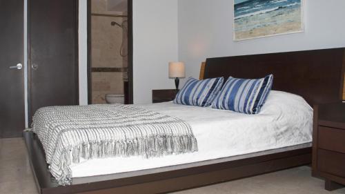una camera da letto con un letto con cuscini blu e bianchi di Chefs Delight a San Juan