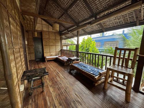 Zimmer mit einer Veranda mit einer Bank und einem Stuhl in der Unterkunft Tranquil Getaway Lilly Room, Dahlia Room, Aster Room and Poppy Room & Dive Center in Mabini