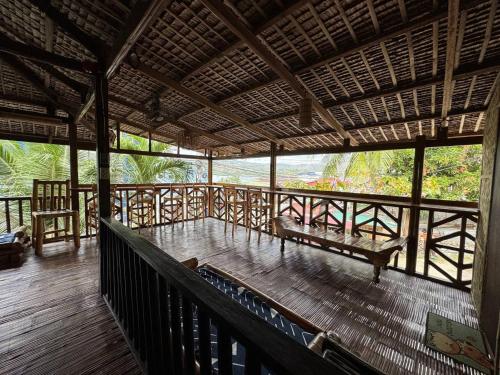 eine Veranda mit einer Bank auf einer Holzterrasse in der Unterkunft Tranquil Getaway Lilly Room, Dahlia Room, Aster Room and Poppy Room & Dive Center in Mabini