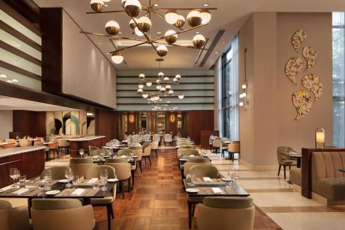 a dining room with tables and chairs and a chandelier at Sheraton Istanbul Levent in Istanbul