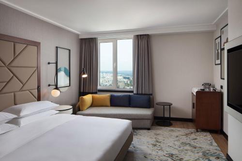 a hotel room with a bed and a couch at Sheraton Istanbul Levent in Istanbul